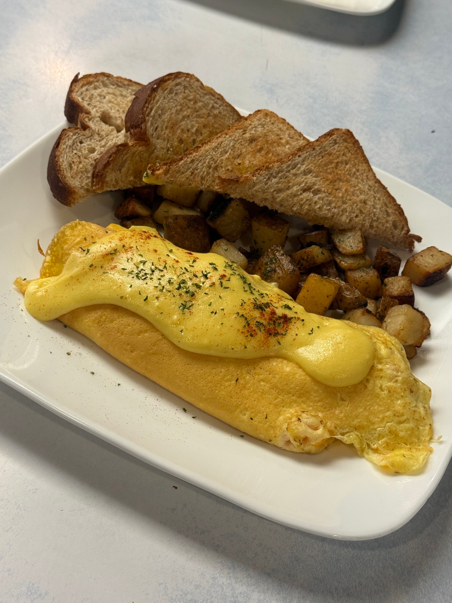 Lobster and cheddar omelette with toast and home fries